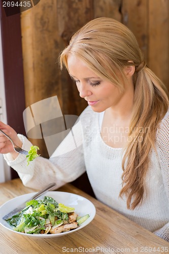 Image of Woman Eating Salad In Restaurant