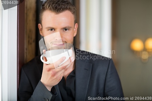 Image of Young Business man Holding Coffee Cup At Cafe