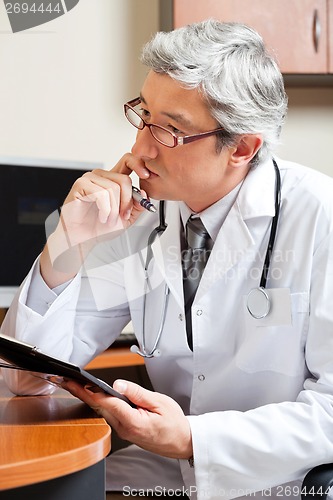 Image of Thoughtful Doctor At Desk