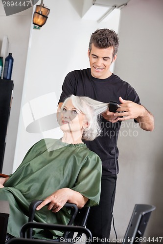 Image of Hairstylist Straightening Female Client's Hair