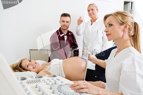 Image of Couple And Doctors Looking At Ultrasound