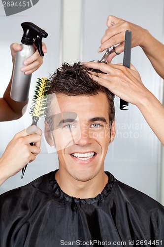 Image of Client With Hairdressers Styling His Hair