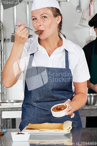 Image of Female Chef Tasting Chocolate Cream