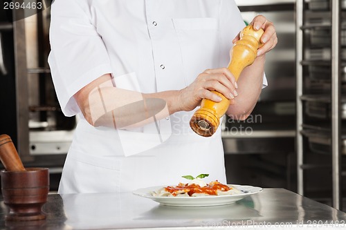 Image of Female Chef With Peppermill Seasoning Dish