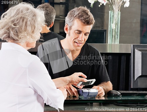 Image of Customer Paying Through Mobile Phone At Salon