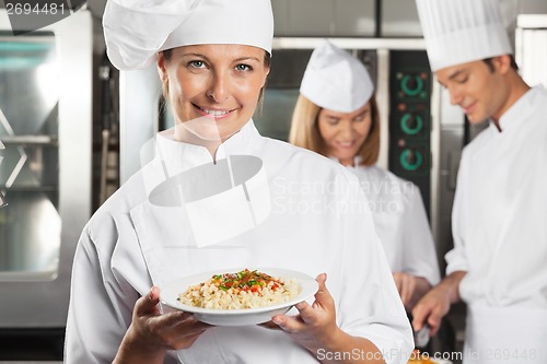 Image of Happy Female Chef Presenting Dish