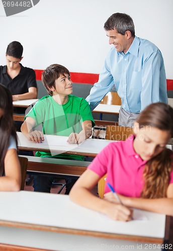 Image of Teacher And Teenage Boy Looking At Each Other During Examination