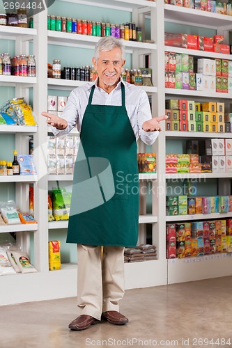 Image of Senior Male Store Owner Welcoming In Supermarket