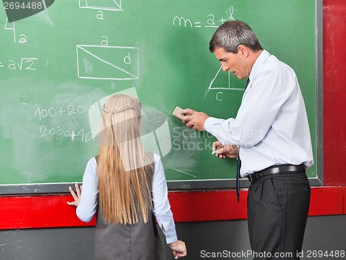 Image of Professor Teaching Mathematics To Little Girl On Board