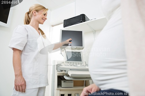 Image of Gynecologist Showing Ultrasound Scan To Pregnant Woman