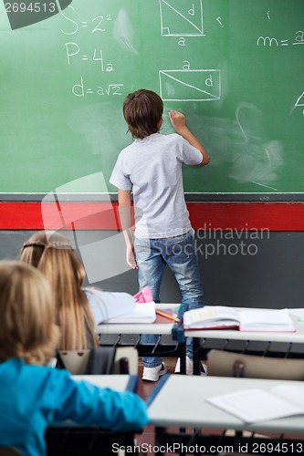 Image of Schoolboy Solving Mathematics On Board