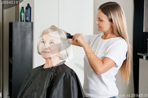 Image of Client Having Hair Straightened By Hairstylist