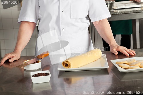 Image of Female Chef With Chocolate Roll On Counter