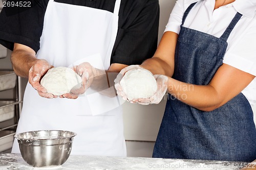 Image of Chefs Presenting Dough In Kitchen