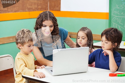 Image of Teacher And Students Using Laptop In Class
