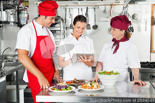 Image of Chefs Using Tablet Computer In Kitchen