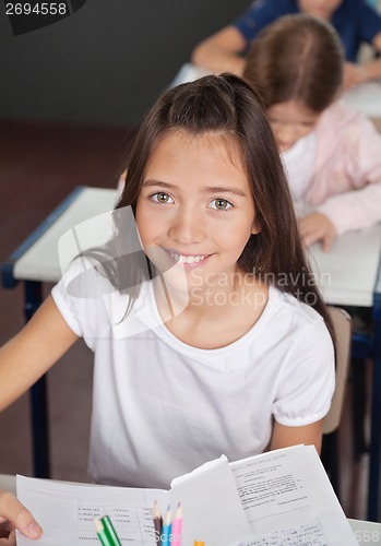 Image of Schoolgirl Sitting At Desk In Classroom