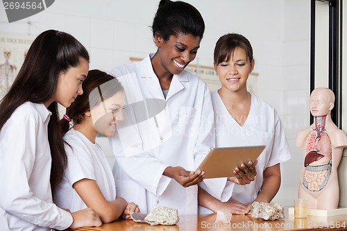 Image of Teacher With Teenage Girls Using Digital Tablet At Desk