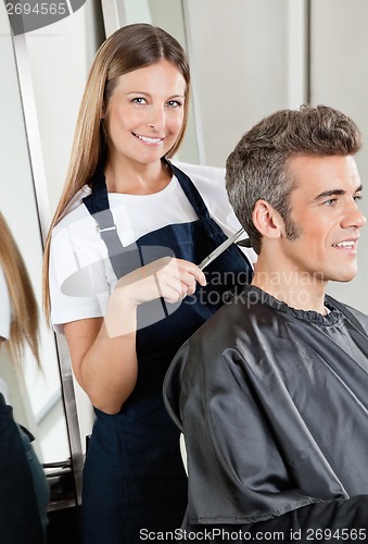 Image of Hairdresser Cutting Client's Hair In Salon
