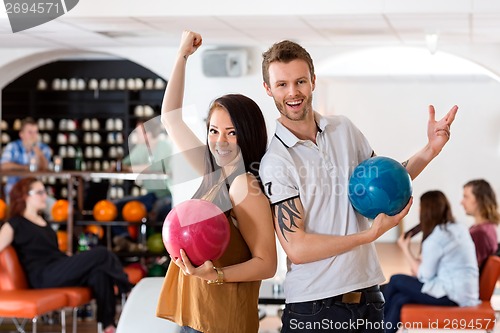 Image of Excited Man And Woman Holding Bowling Balls