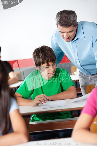 Image of Schoolboy And Professor Looking At Paper During Examination