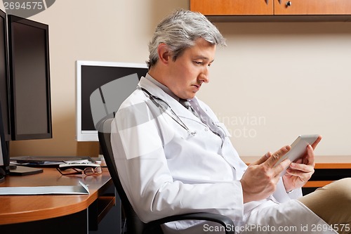 Image of Serious Doctor Looking At Digital Tablet