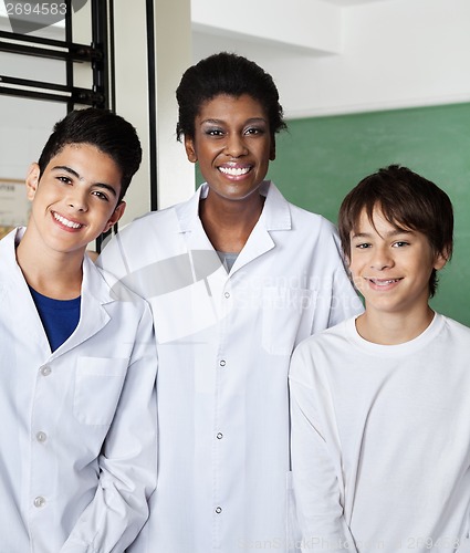 Image of Teacher Standing With Male Schoolchildren In Classroom