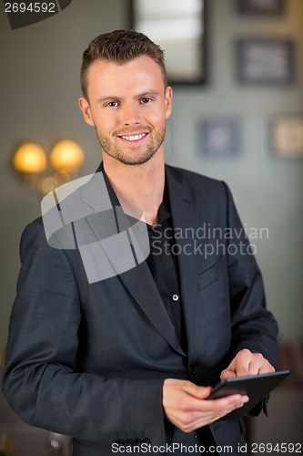 Image of Businessman Holding Digital Tablet At Cafe