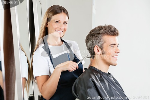 Image of Hairstylist Giving Haircut To Customer