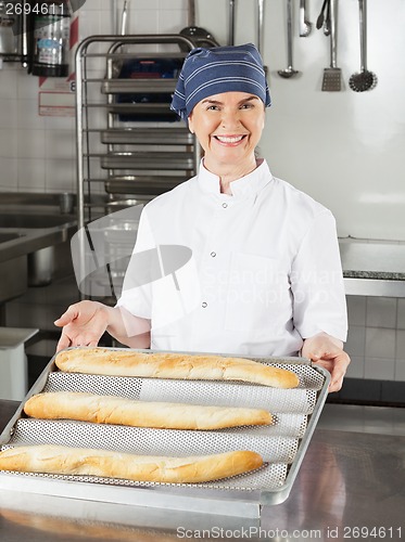 Image of Female Chef Presenting Loafs Of Bread