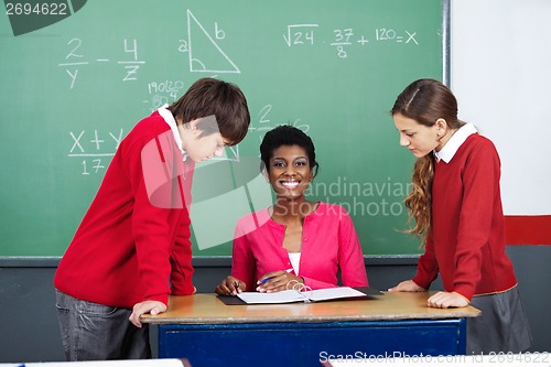 Image of Teacher With Students At Desk