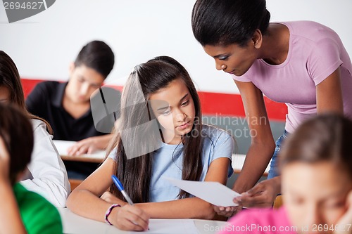 Image of Teacher Assisting To Teenage Girl