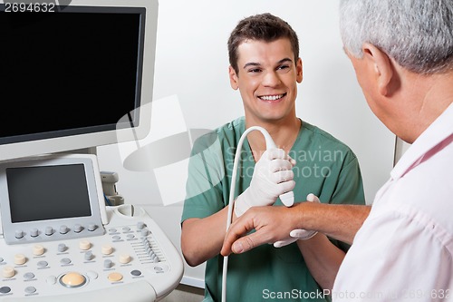 Image of Happy Technician Scanning Male Patient's Hand