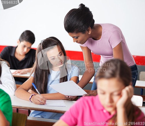 Image of Teacher Showing Paper To Teenage Girl During Examination
