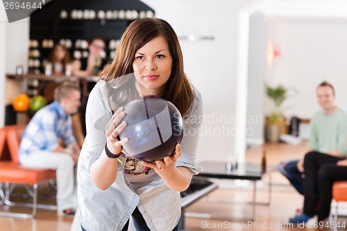 Image of Young Woman Ready With Bowling Ball in Club