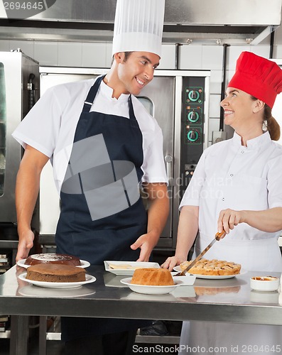 Image of Happy Chefs Preparing Sweet Dishes in Kitchen