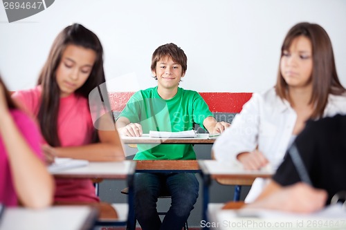 Image of Teenage Schoolboy Sitting In Classroom