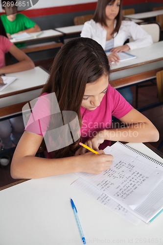 Image of Teenage Schoolgirl Writing At Desk