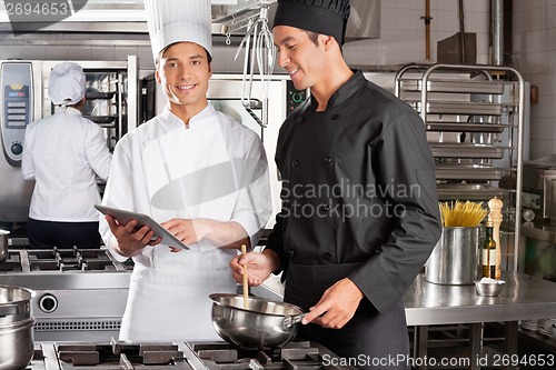 Image of Chef Assisting Colleague In Preparing Food