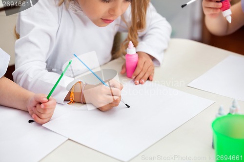Image of Girl Painting At Desk In Preschool