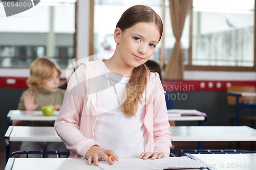 Image of Little Girl Studying While Standing At Desk