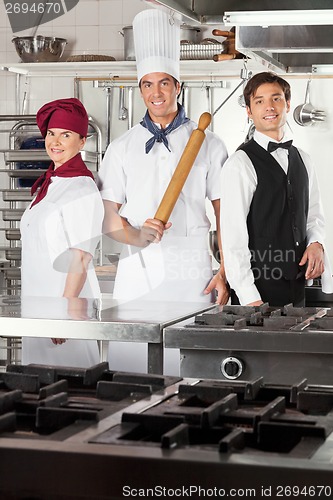 Image of Confident Chefs And Waiter In Kitchen