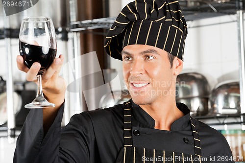 Image of Chef Looking At Glass Of Red Wine