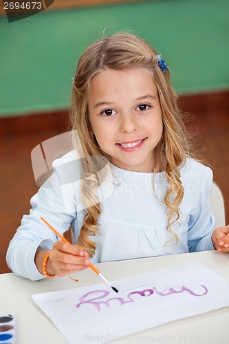 Image of Girl Drawing At Desk In Kindergarten