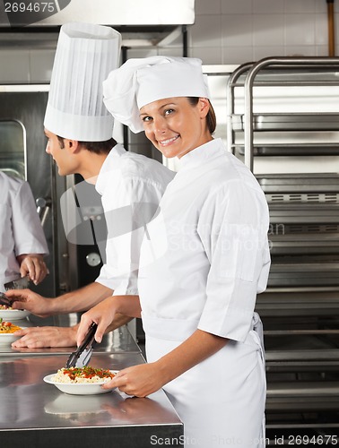 Image of Female Chef Working In Restaurant Kitchen