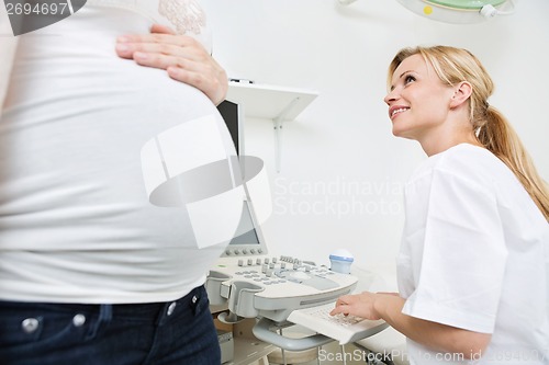 Image of Doctor Preparing For Ultrasound Scan While Looking At Pregnant W