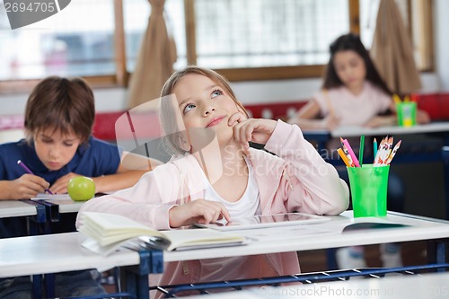 Image of Schoolgirl With Digital Tablet At Desk Looking Up