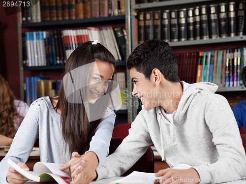 Image of Girl Holding Boy'S Hand While Sitting In Library