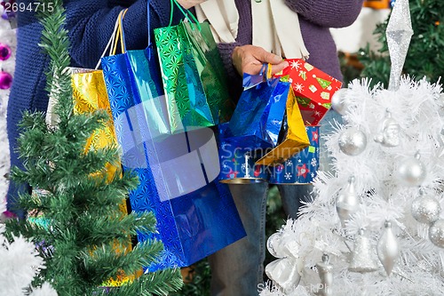 Image of Shopaholic Couple Carrying Shopping Bags At Christmas Store