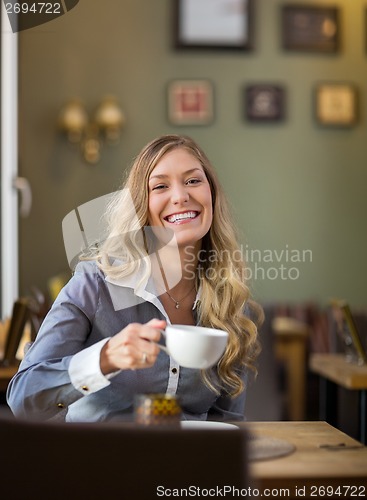 Image of Happy Woman Drinking Coffee At Coffeeshop